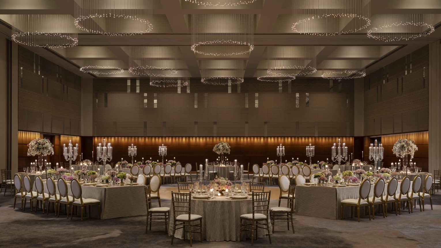 A large ballroom with large tables and many chairs.