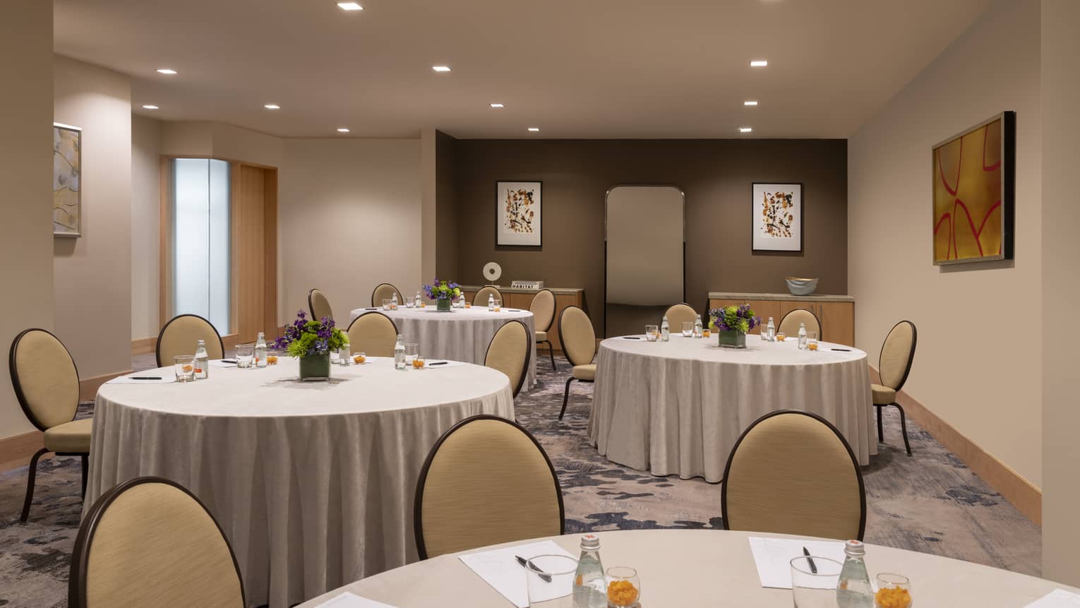 A room with round tables with chairs.