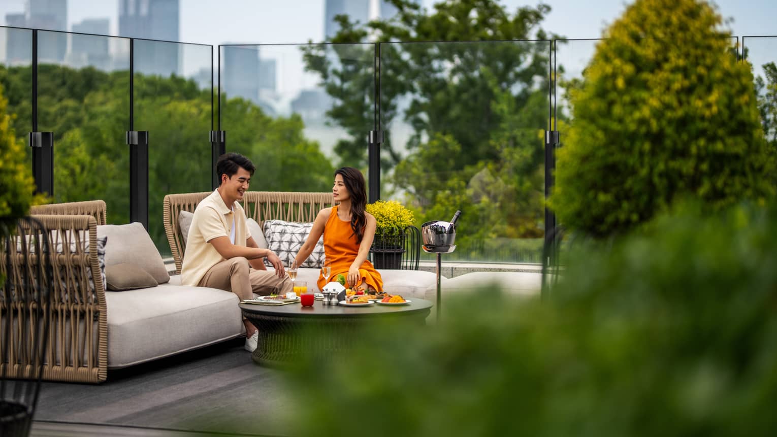 Man and woman dine on Yun He restaurant terrace at Four Seasons Hotel Suzhou, with Suzhou city in background