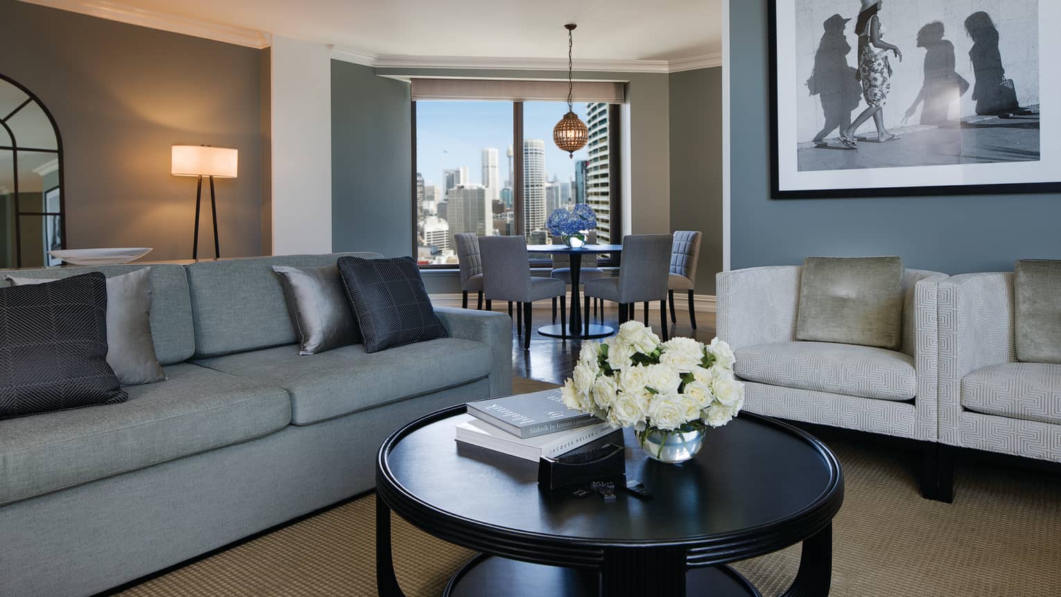 Royal Suite sofa with silver pillows, round table, black-and-white framed print, dining alcove