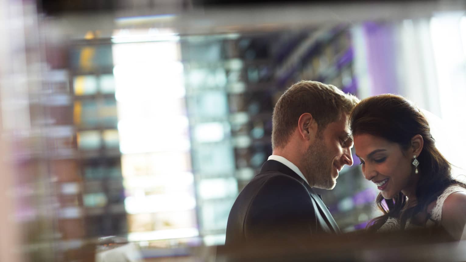 Groom leans in to whisper to bride in Aria wedding event space 