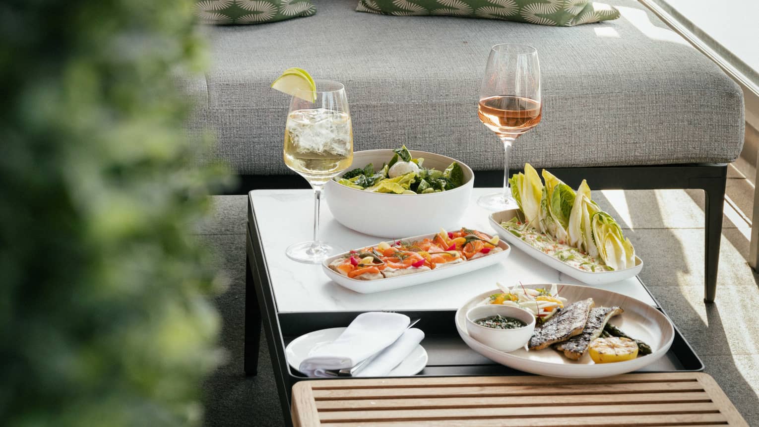 Four brunch dishes with two glasses of wine on wooden coffee table