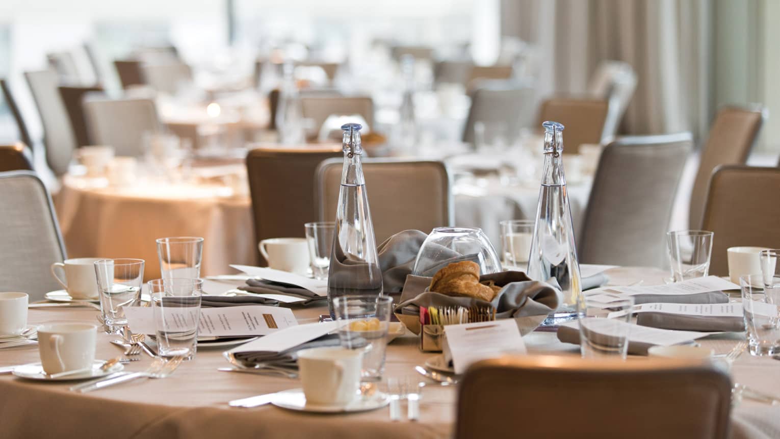 Bottles of water, glasses on round formal banquet table
