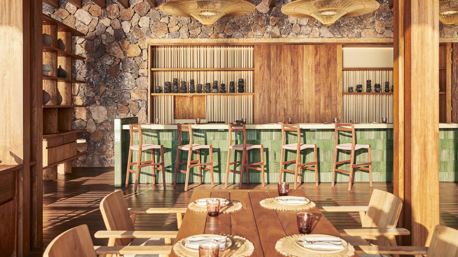 A raw bar in a dining outlet made of wood and stone, a dining table is seen nearby.