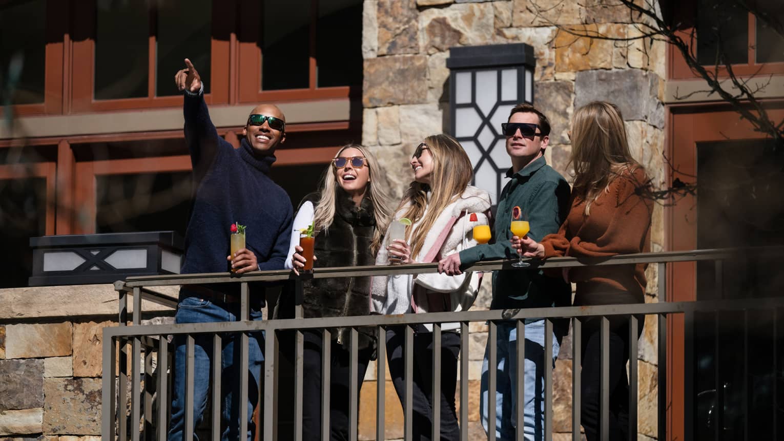 Five guests standing together on a balcony.