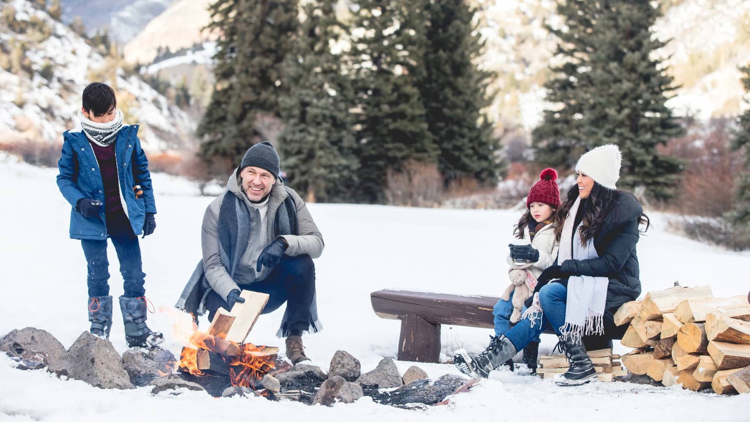 Family of four enjoying an outdoor fire