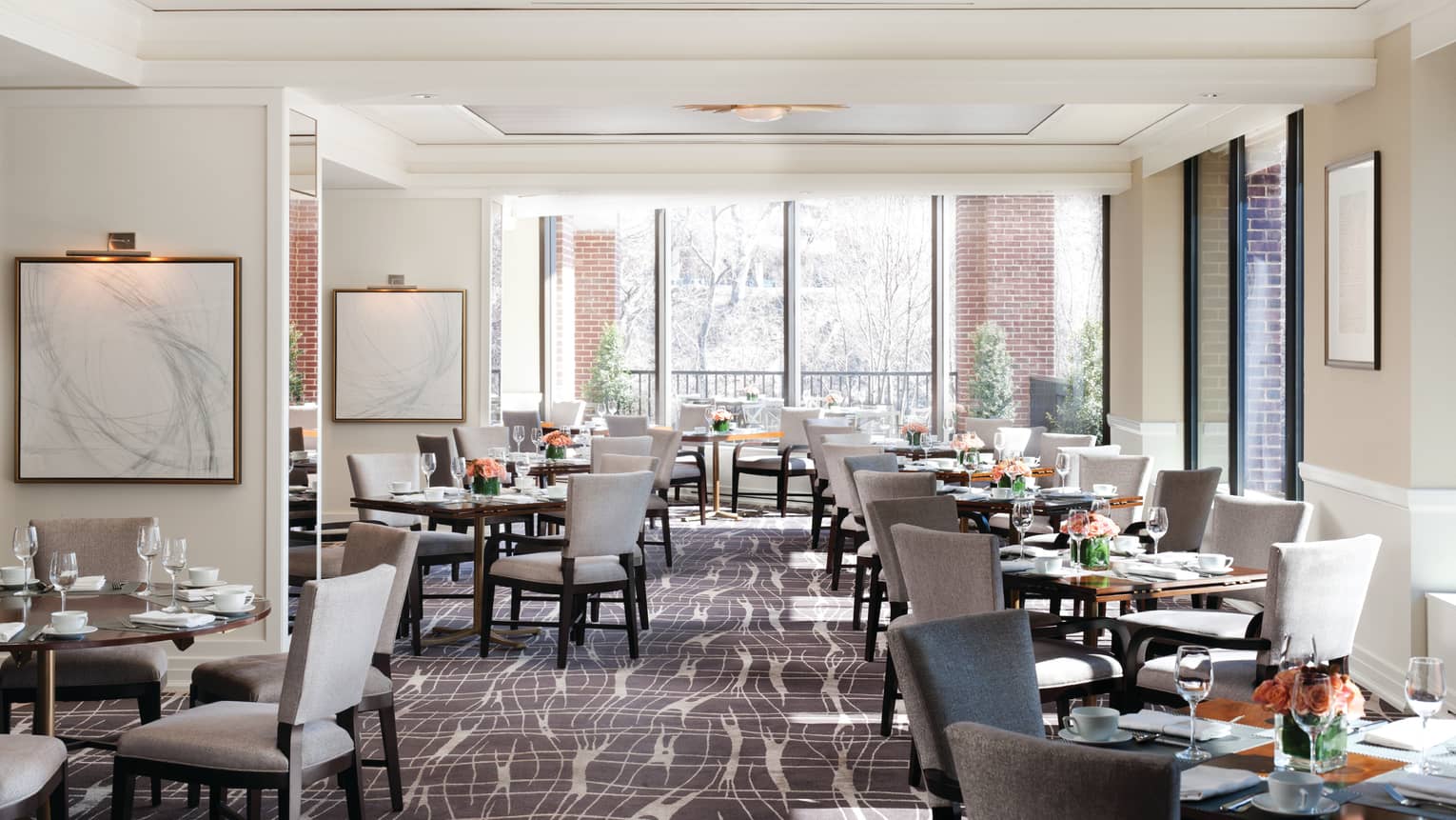 Bright Seasons dining room with grey pattern carpet, dining tables and chairs along corner windows