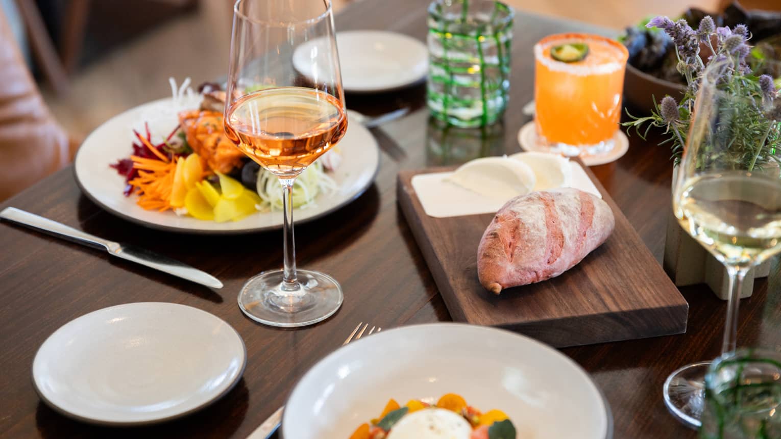 A dining table set with two dishes and two wine glasses
