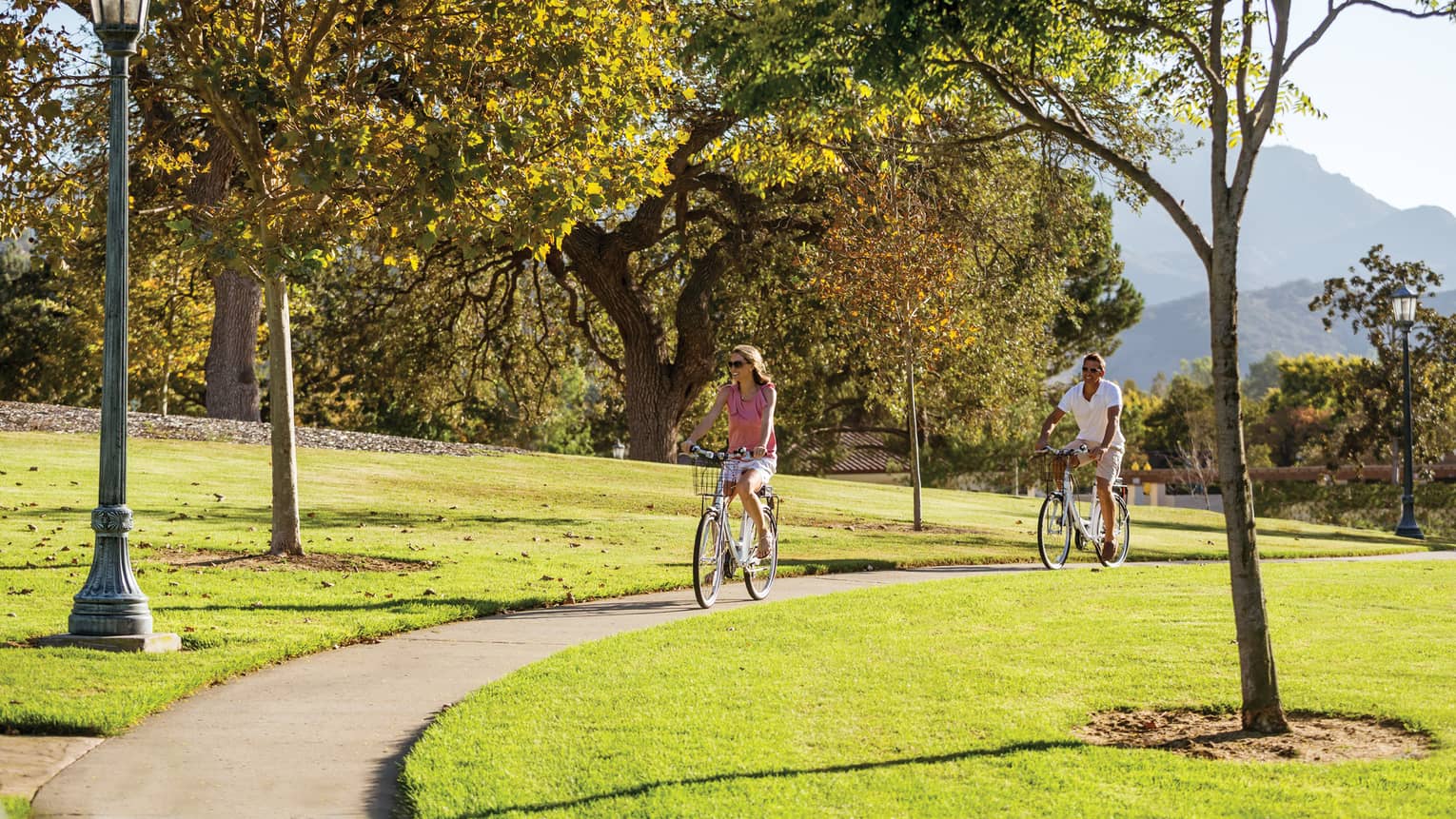 Two guests riding bicycles on an outdoor trail.