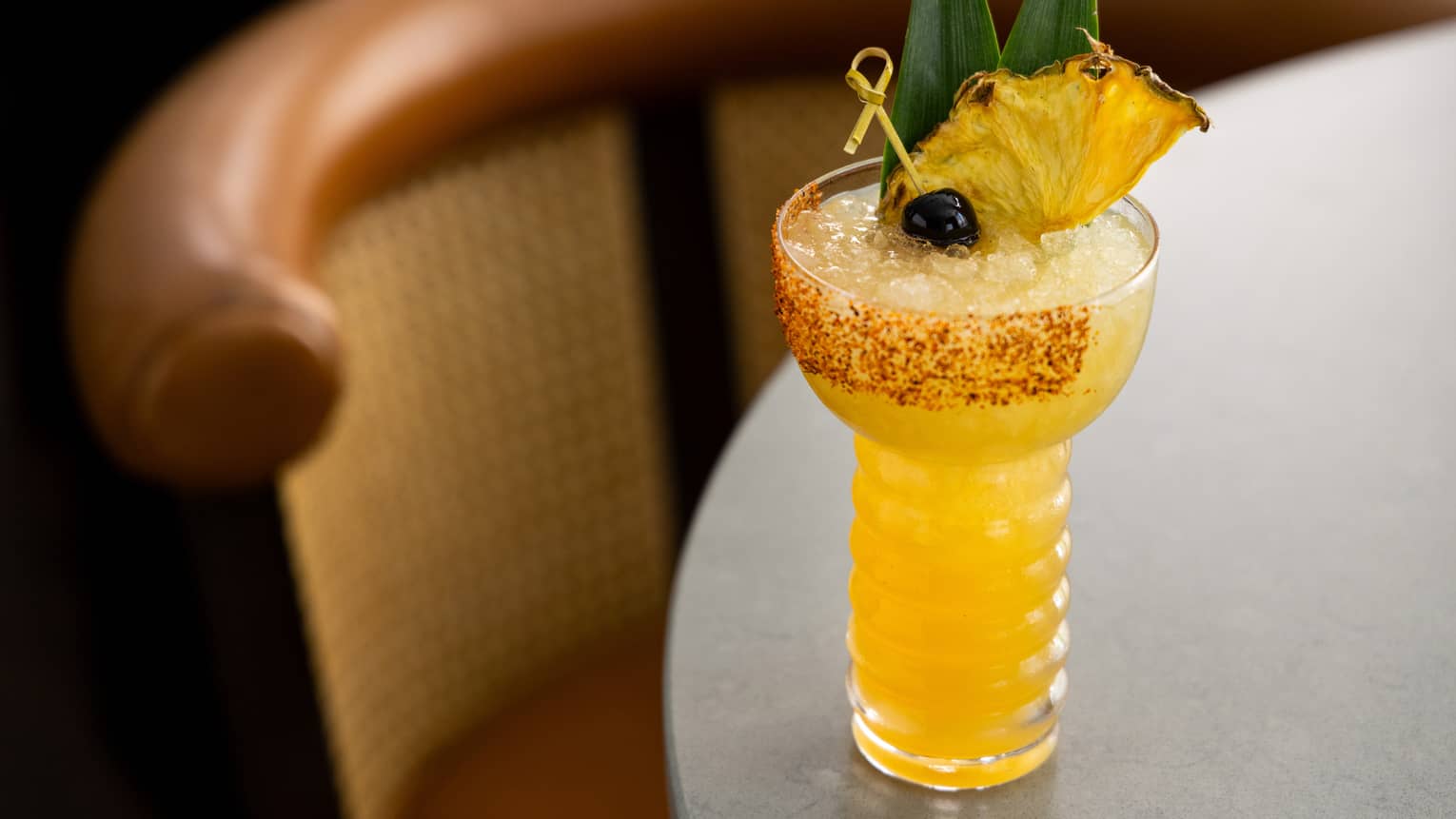 A yellow cocktail with a spiced rim.