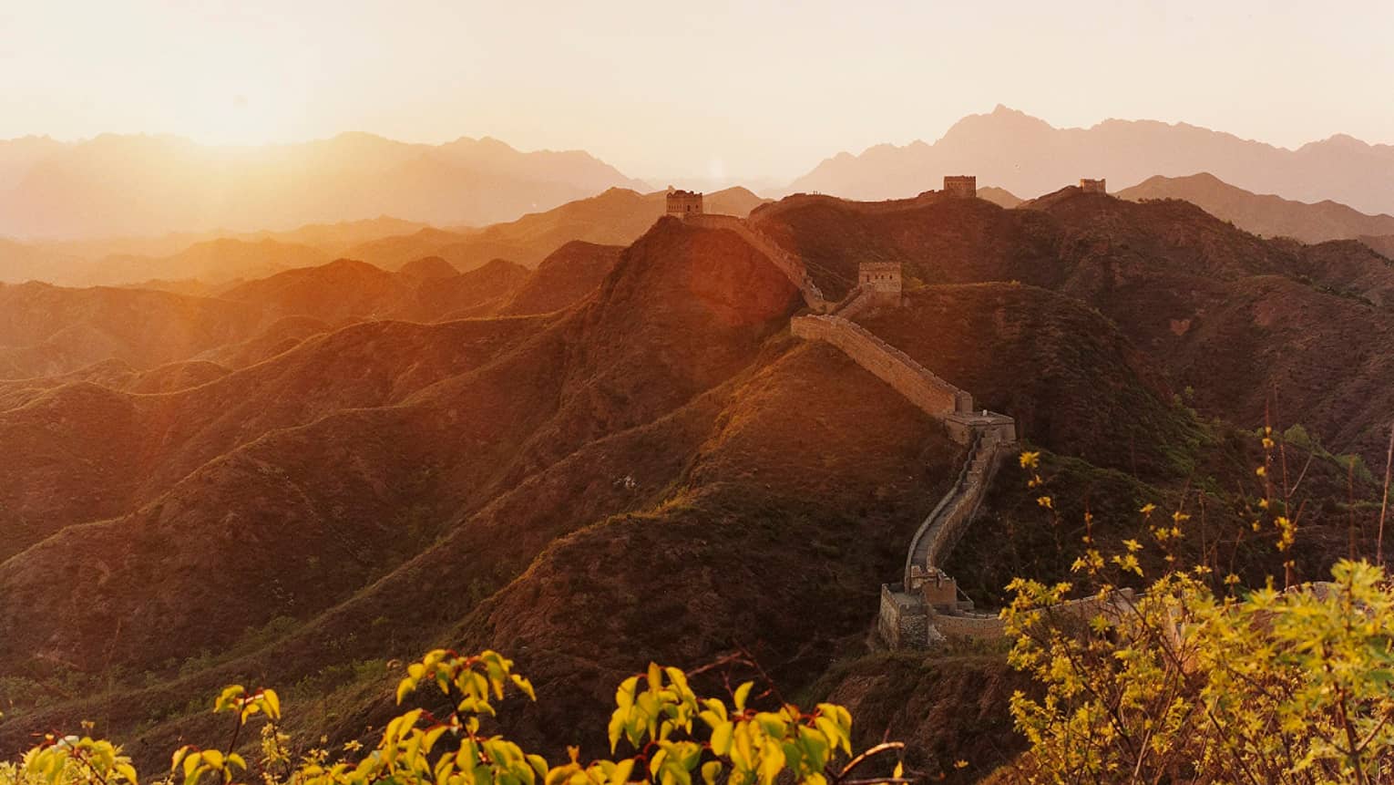 Sunset over mountain, trees with Great Wall of China along side
