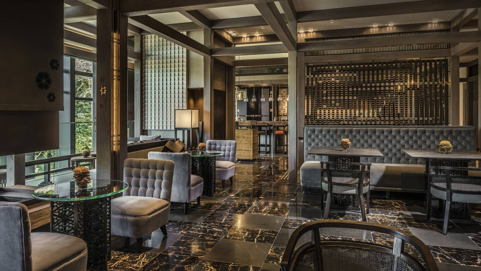 Plush grey velvet sofas, chairs on black marble floors in The Lounge dining room