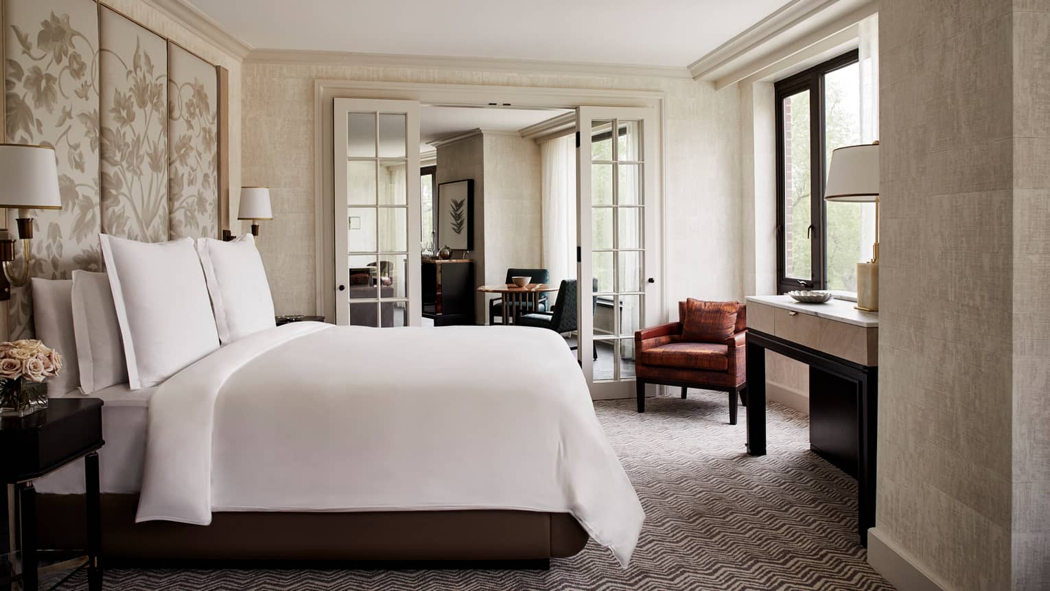 State Suite bedroom with white bed and fabric floral headboard, glass French doors to living room
