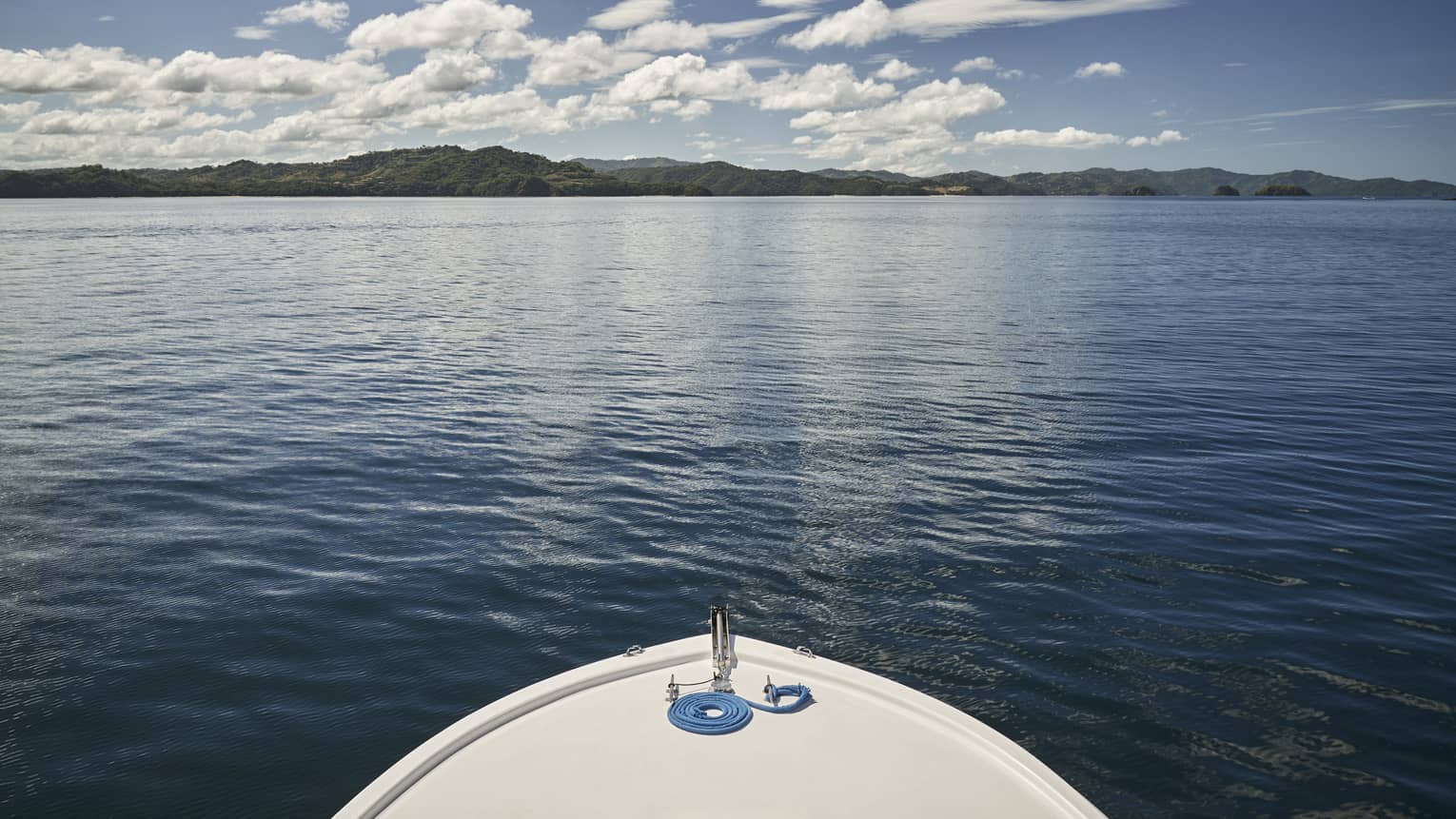 The front edge of a boat looking at water.