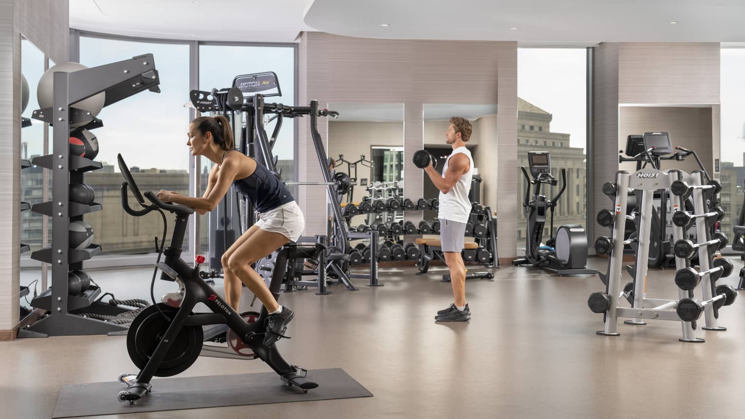 A man and woman using gym equipment.