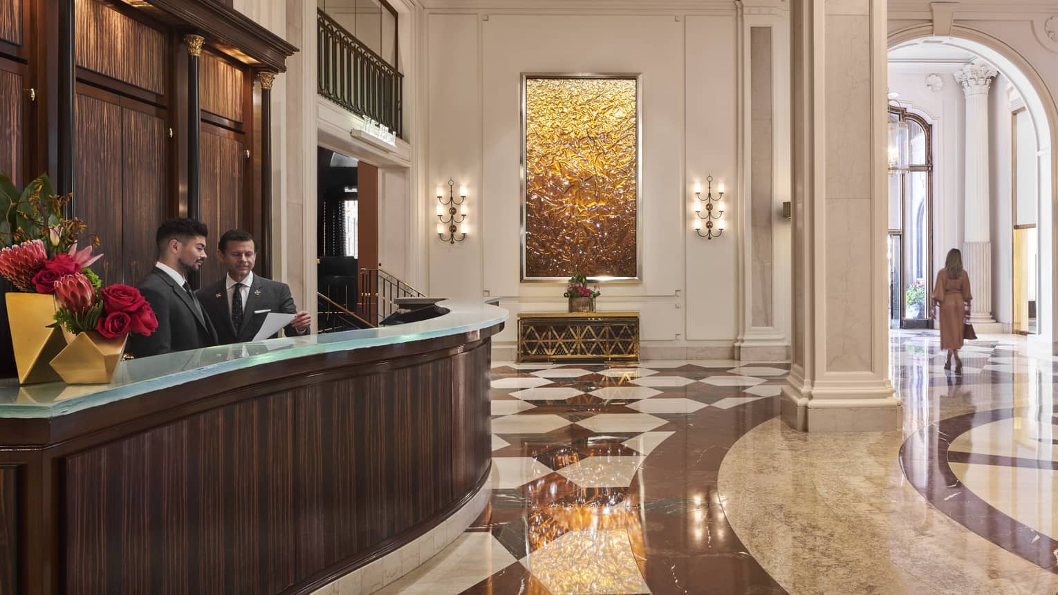 The large concierge desk of a well lit hotel lobby.