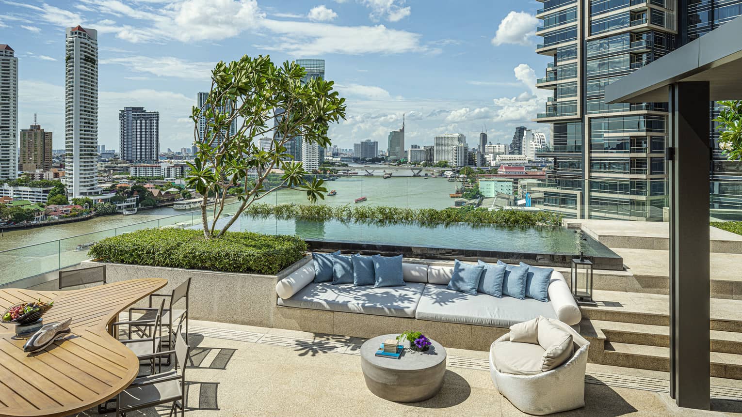 Private outdoor terrace with built-in sofa and pool with Bangkok river view