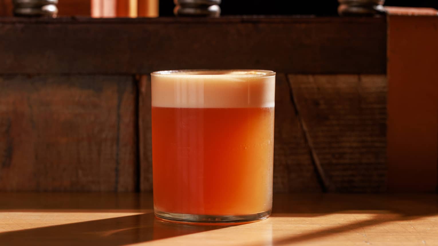 Orange-coloured cocktail in a rocks glass