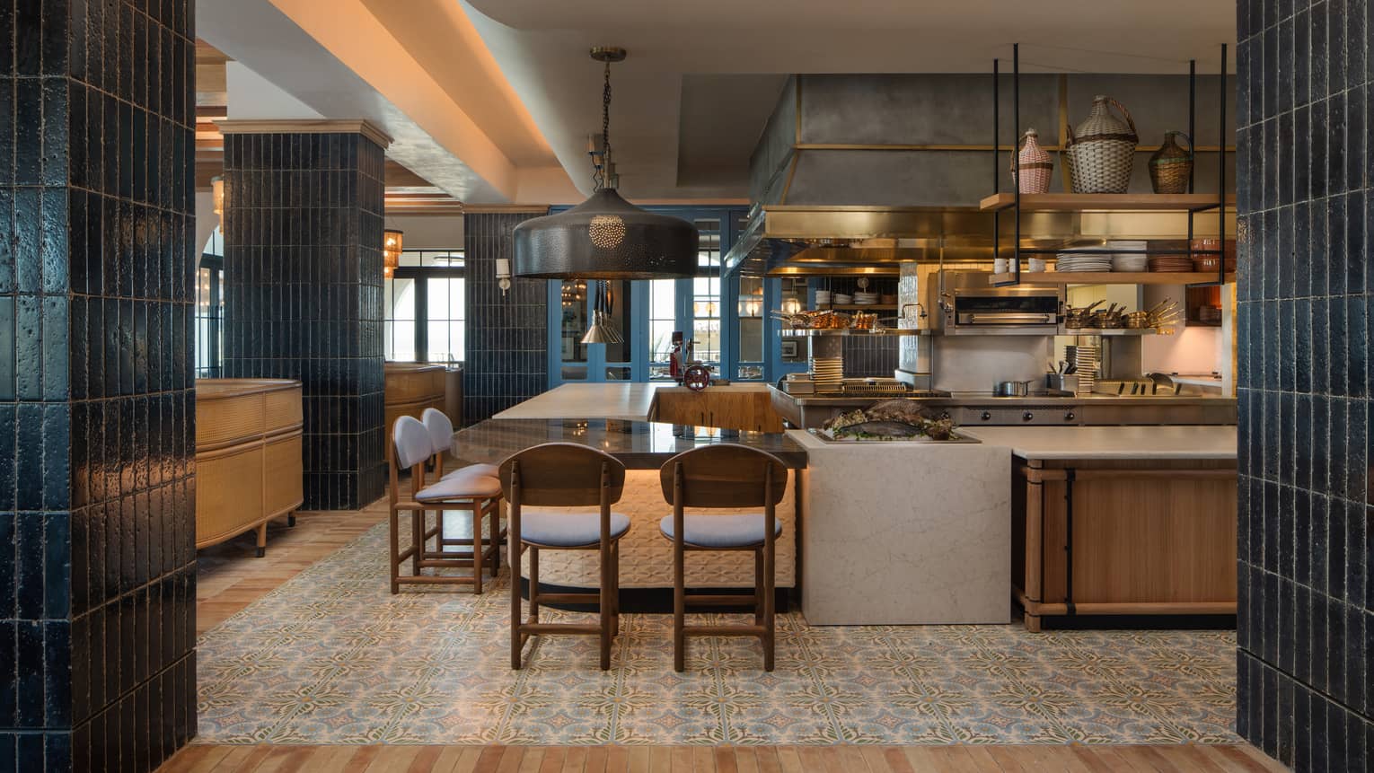 Interior of bar counter at a restaurant facing an open kitchen