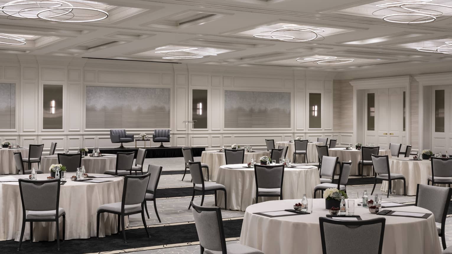 White ballroom with set round tables and muted artwork