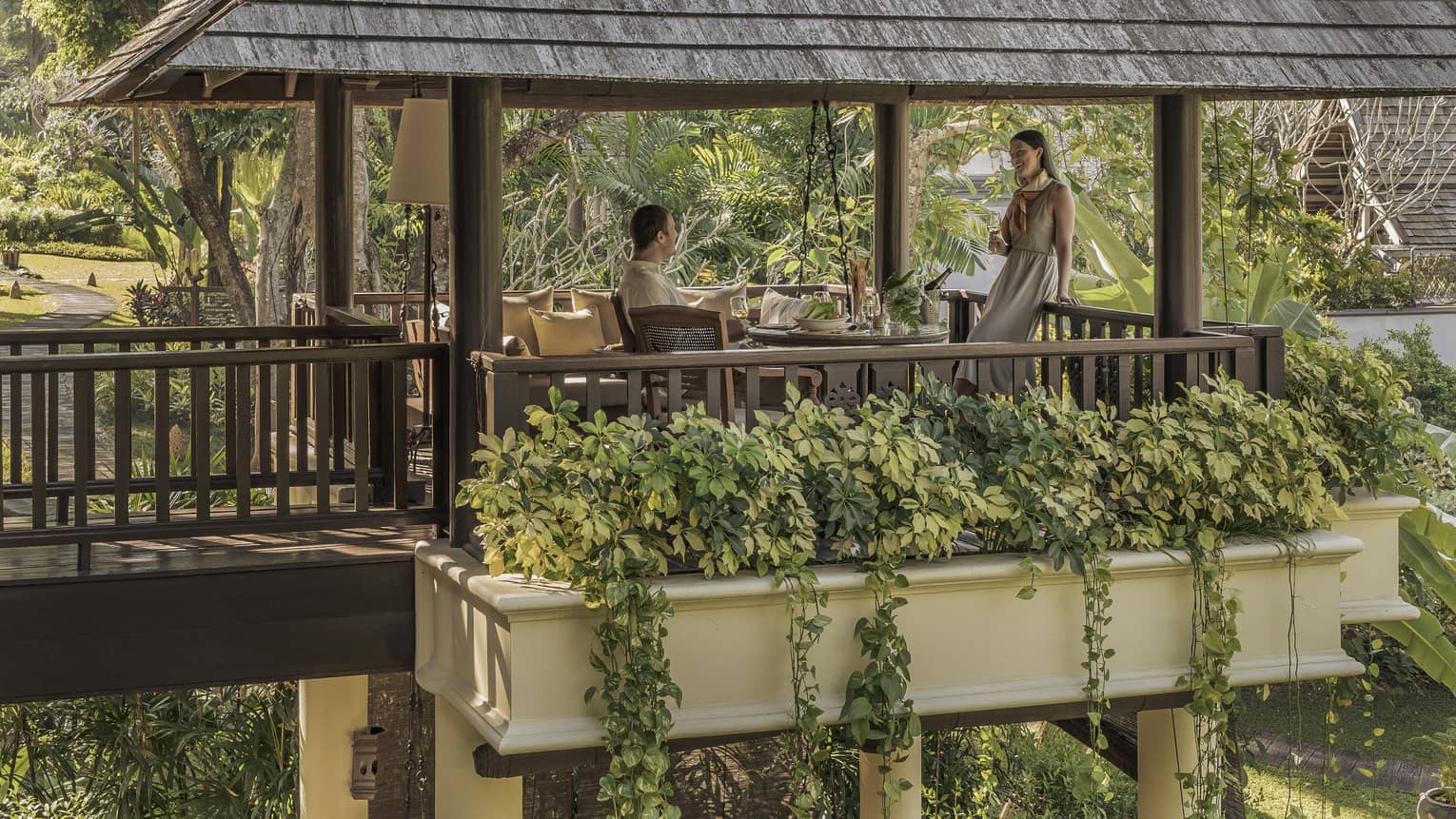 Couple enjoys a meal on the pavillion surrounded by greenery
