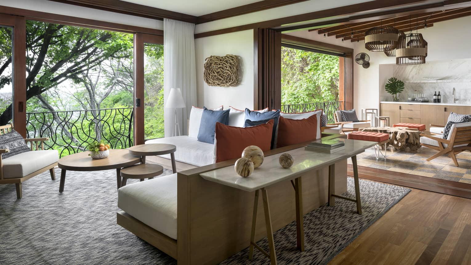Pacifico Three-Bedroom Resort Residence airy living room, back of L-shaped sofa with wood frame, table with marble spheres