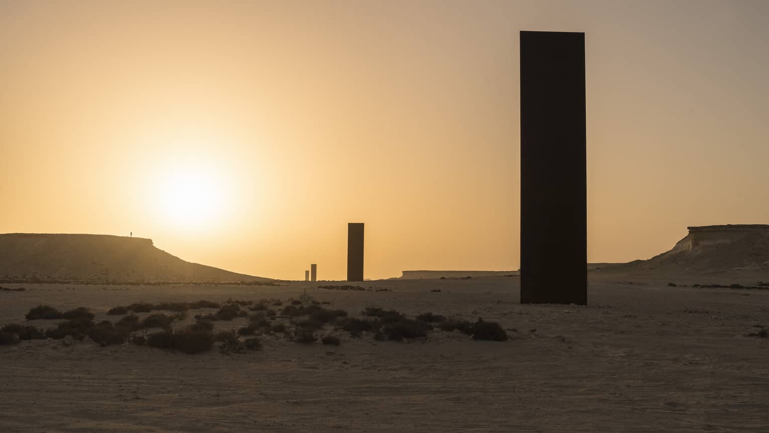 Silhouettes of Richard Serra Sculpture against sunset