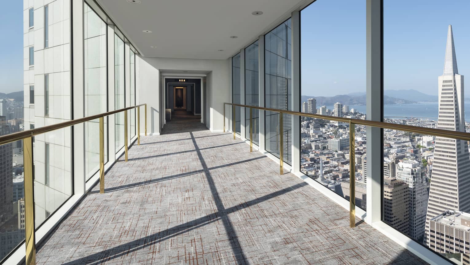 Hallway with floor-to-ceiling windows on both sides.