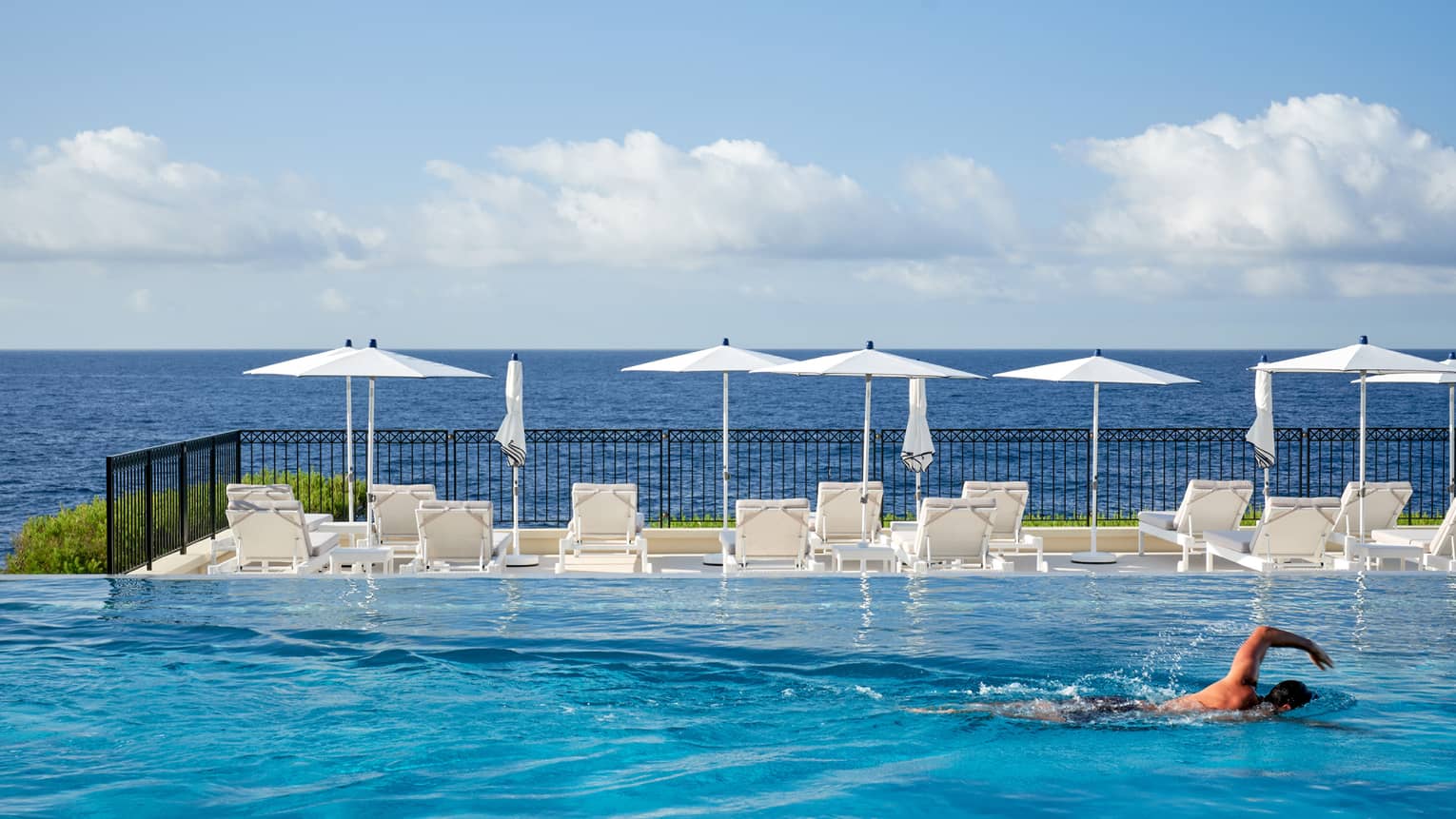 Man swimming in infinity pool