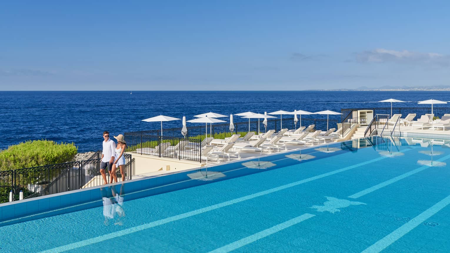 A couple walking around a luxury hotel pool