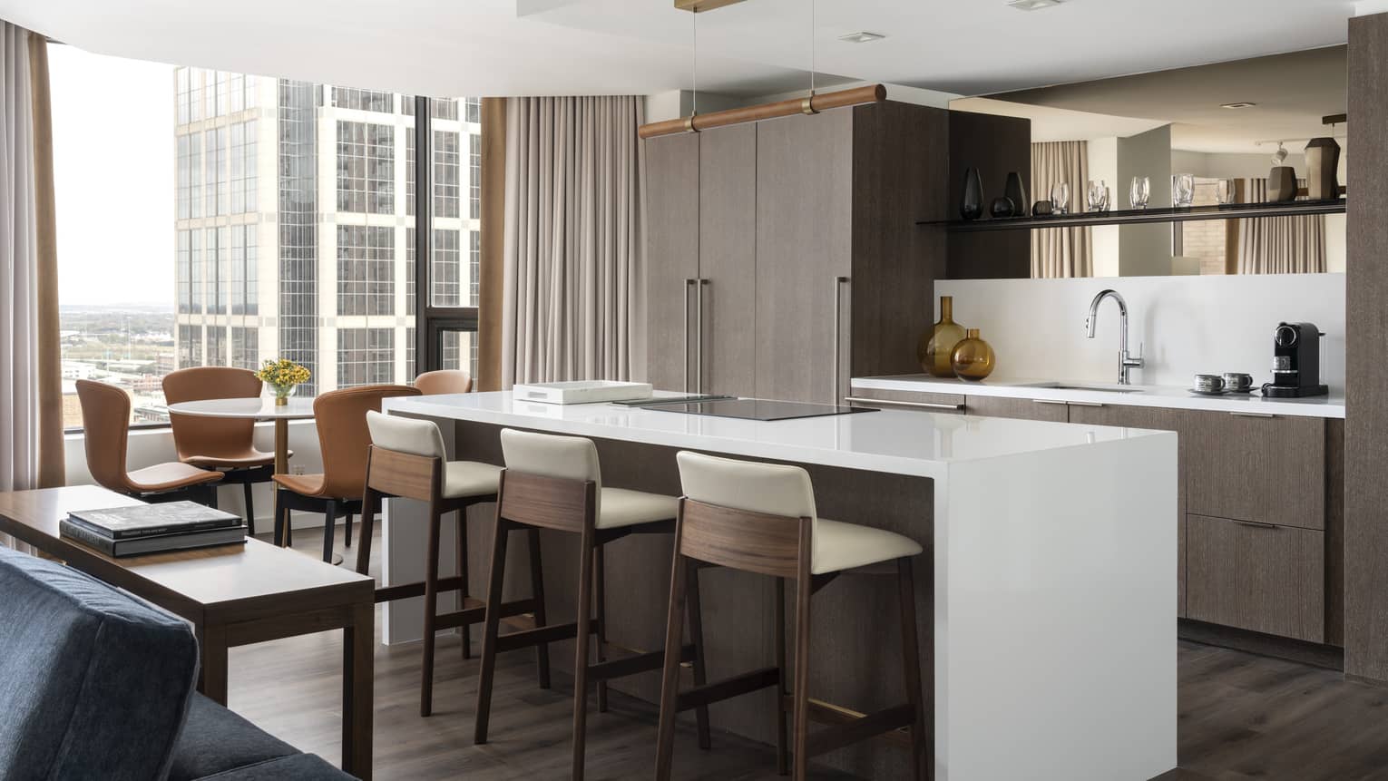 A kitchen area with large island near large windows in a hotel suite.