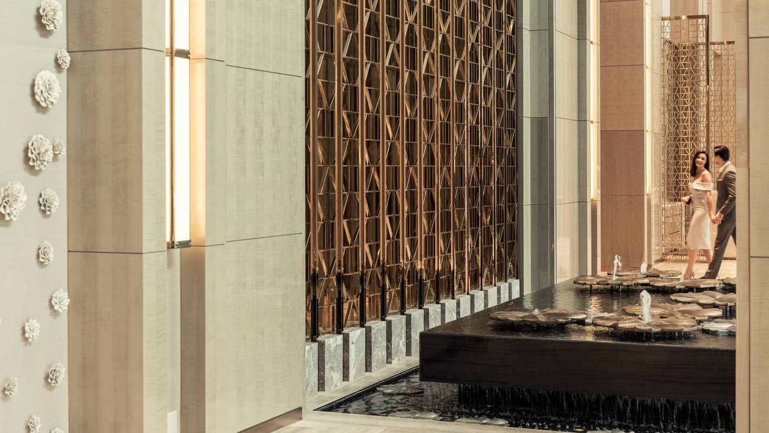 A couple walks through the lobby at Four Seasons Hotel Kuala Lumpur