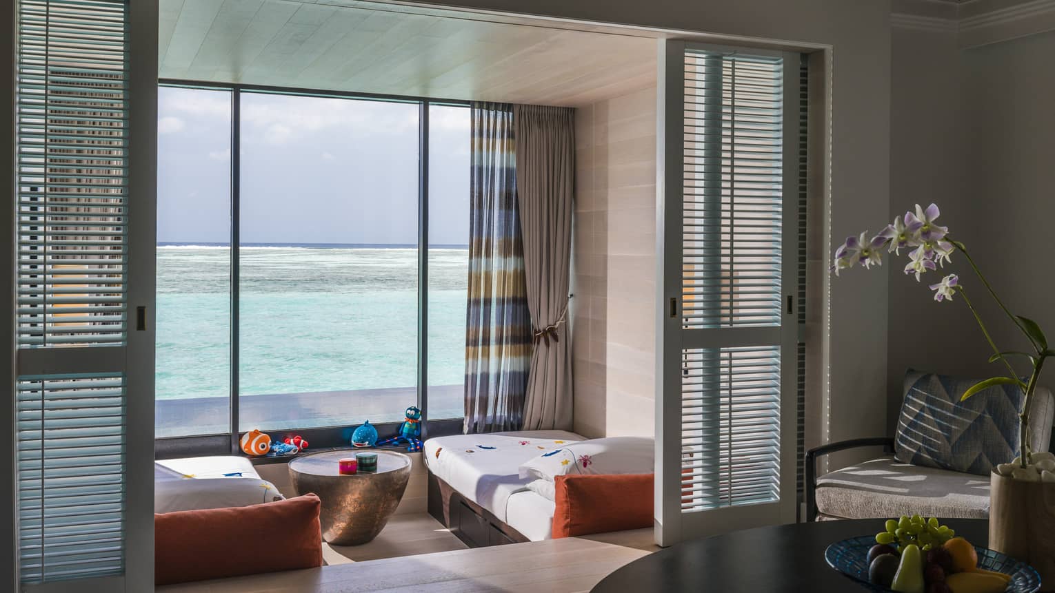 A kids' bedroom in a family villa overlooking a calm ocean