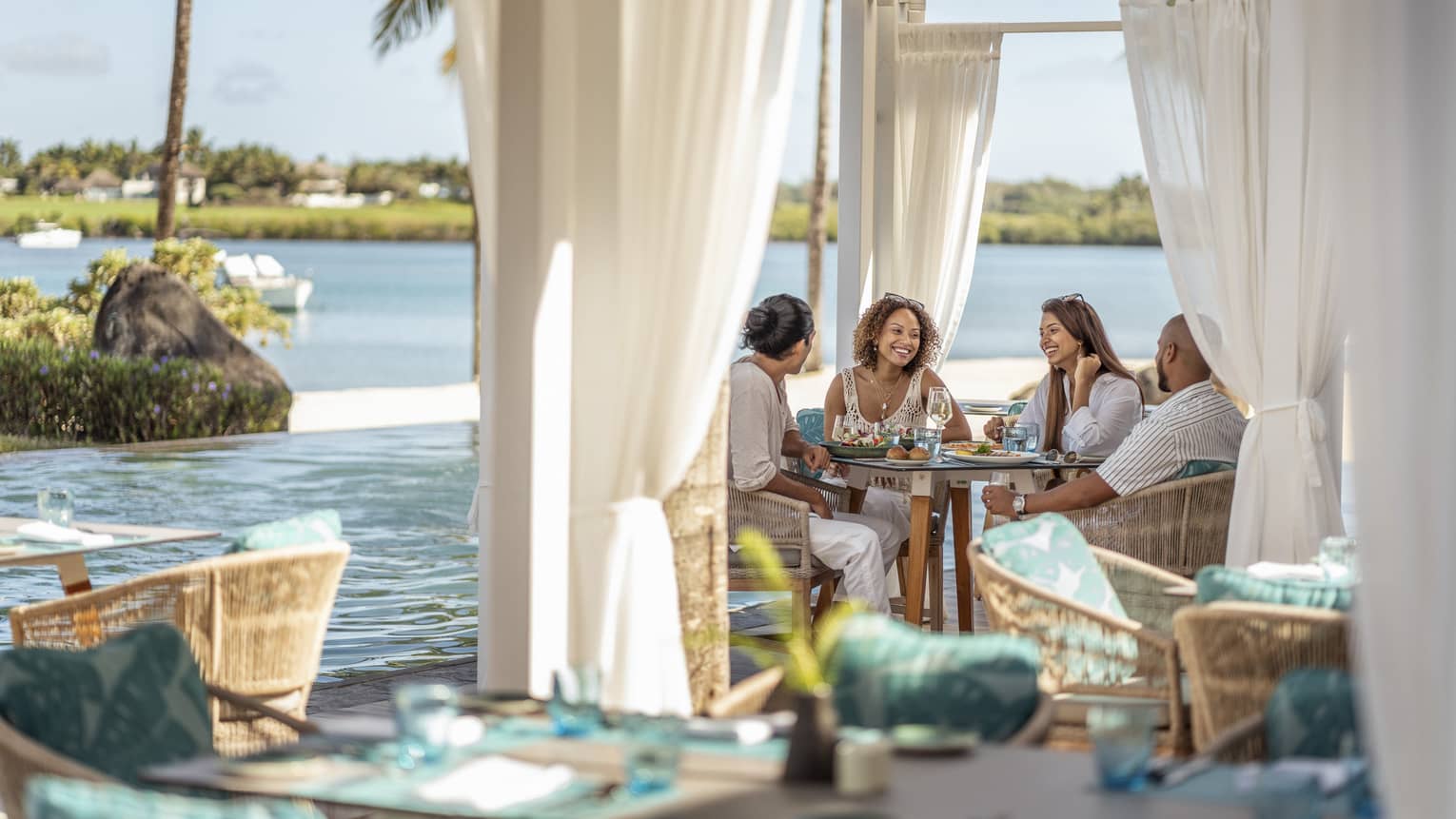 A group dines in an outdoor pavilion with an ocean view
