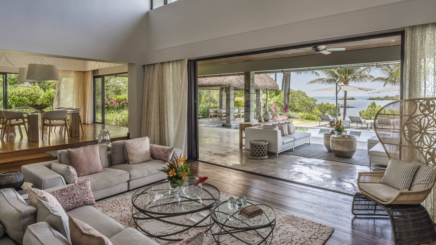 Large living room with high ceilings, two sofas, large opening to outdoor terrace