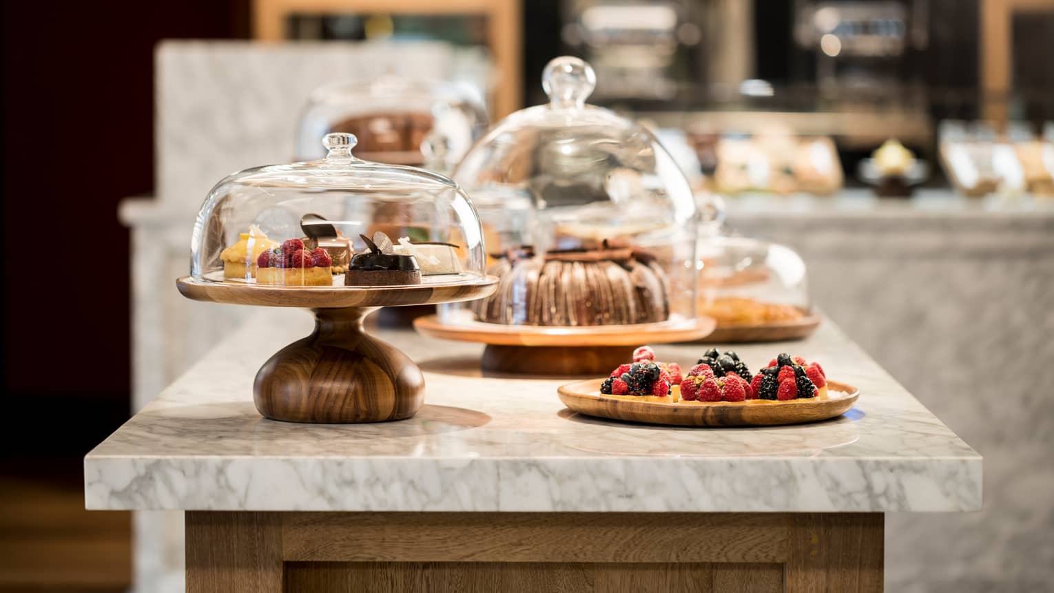 Sweets, desserts and pastries in glass cake displays on Pan Dulce white marble counter