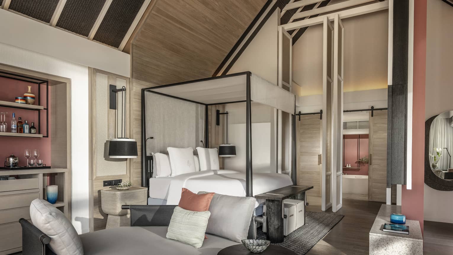 Master bedroom with vaulted beamed ceiling, canopy bed and lounge seating