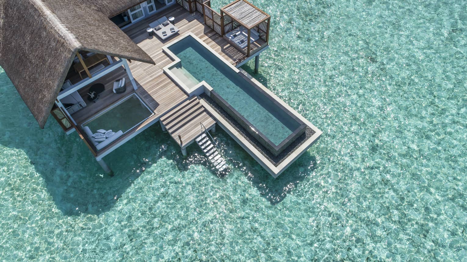 Aerial view of lure island villa with private pool and deck surrounded by crystal ocean