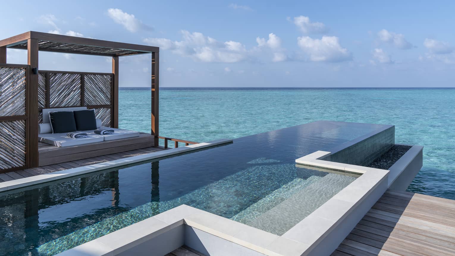An oceanside infinity pool with a covered cabana 
