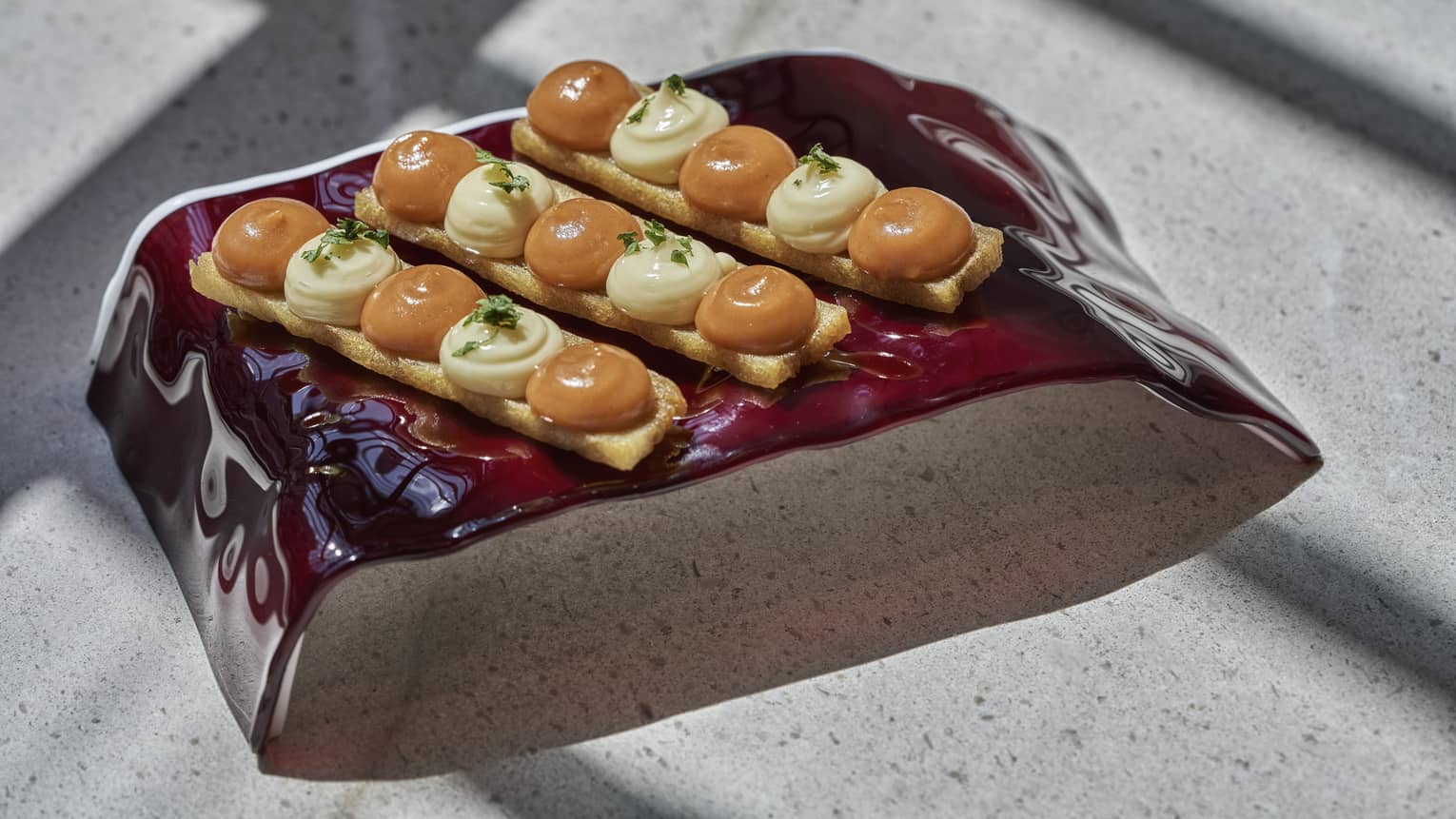 Patatas Bravas with Potato Millefeuille and Spicy Sauce on modern brown plate
