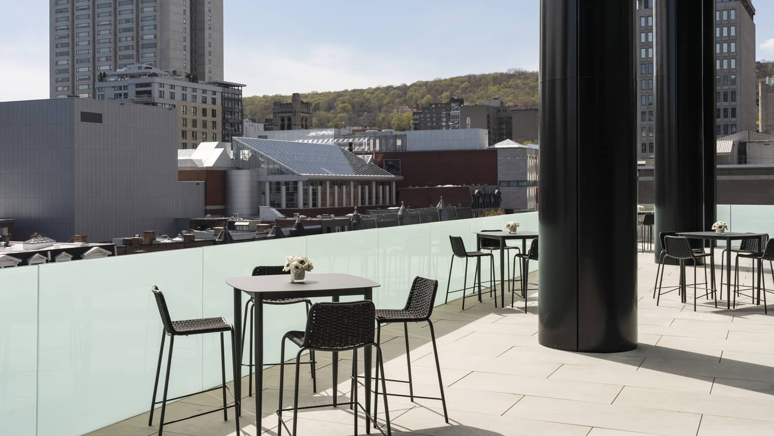 Black tables with flowers and chairs Belvedere Terrace, overlooking city 