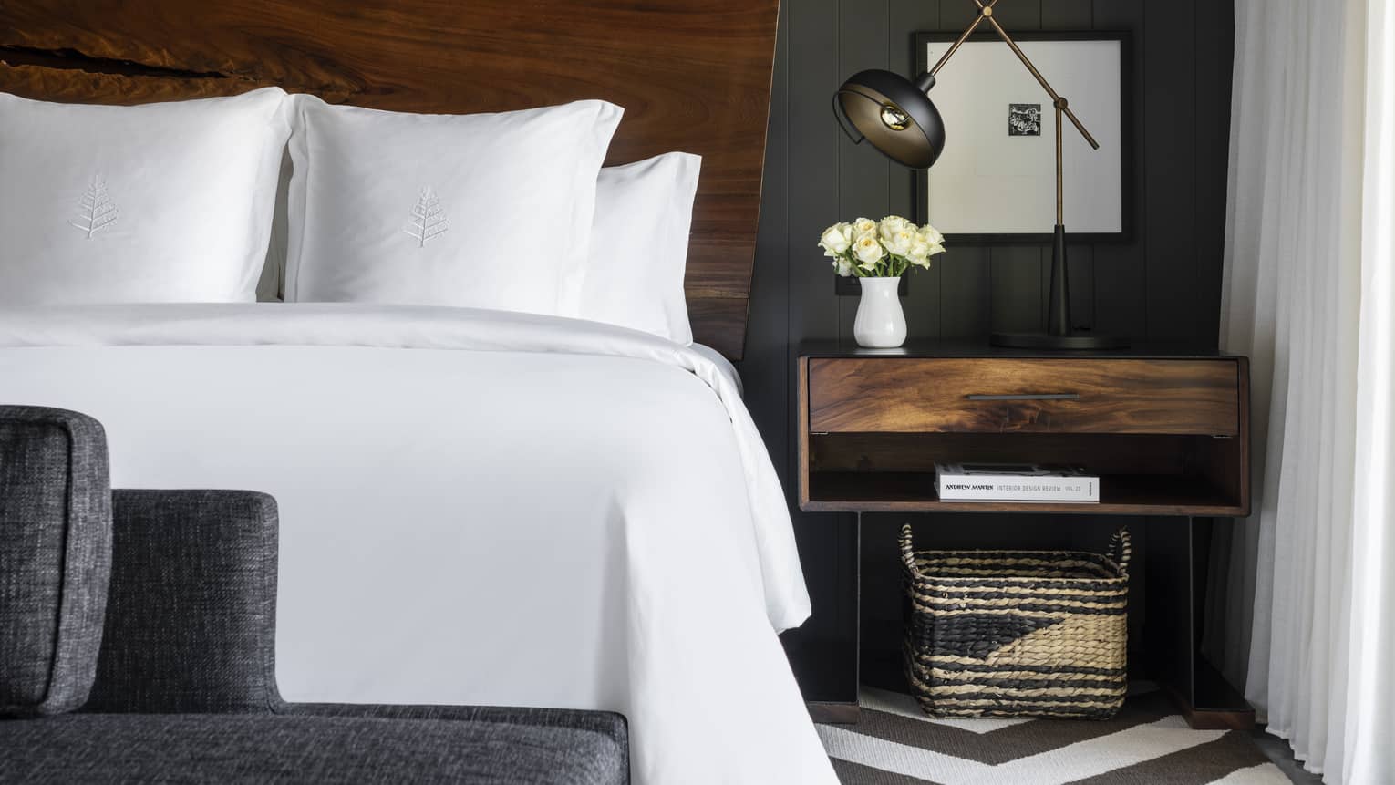 White king bed with natural wood headboard, modern wooden night stand and lamp