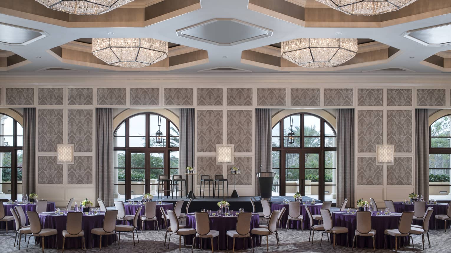 A ballroom at four seasons resort orlando at walt disney world is ready for guests with circular tables covered in purple table cloths