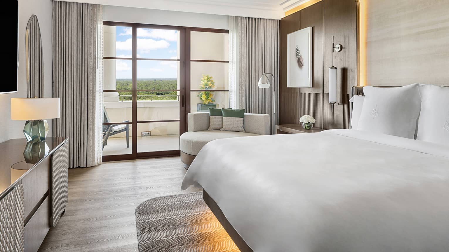 Contemporary hotel room with king bed and walk-out balcony