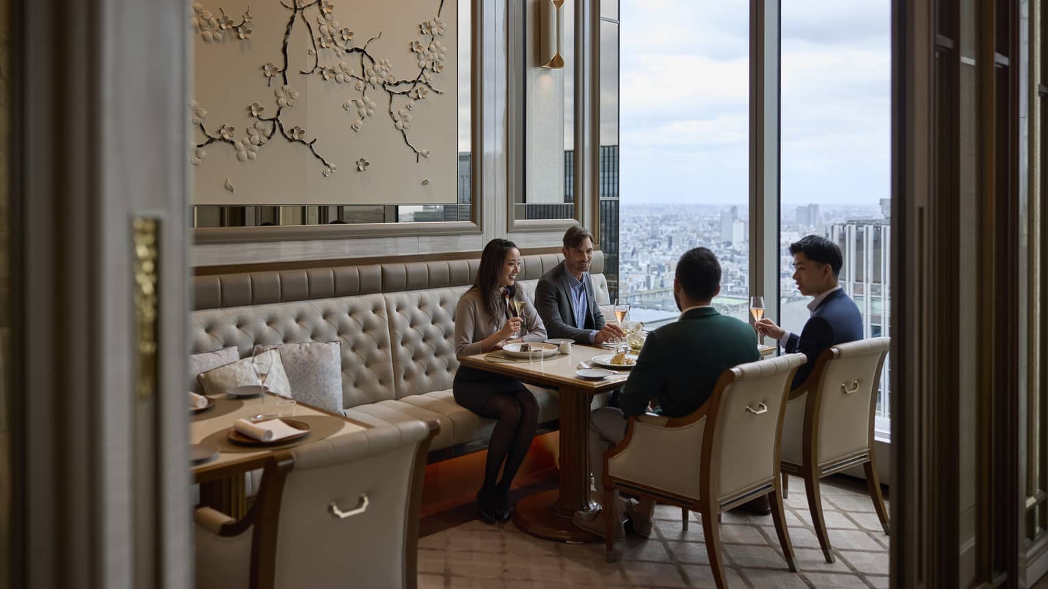A group dines in a semi-private room at est, a French restaurant in Tokyo, with stunning city views.