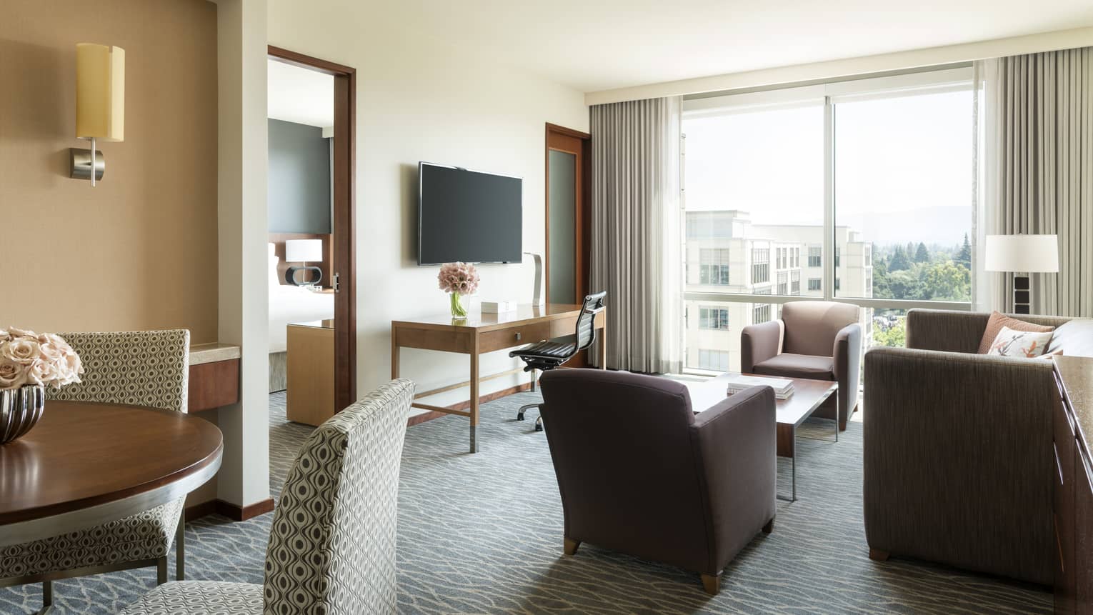 Silicon Valley Suite sunny seating area, dining table, TV, door to bedroom