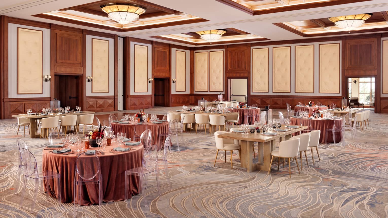 A room with large round and rectangular tables covered in pink cloth.