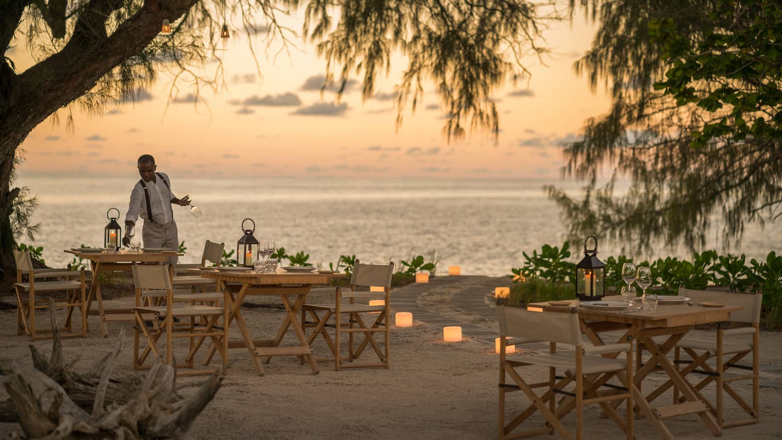 Lighthouse Restaurant on beach decorated with luminaries at sunset