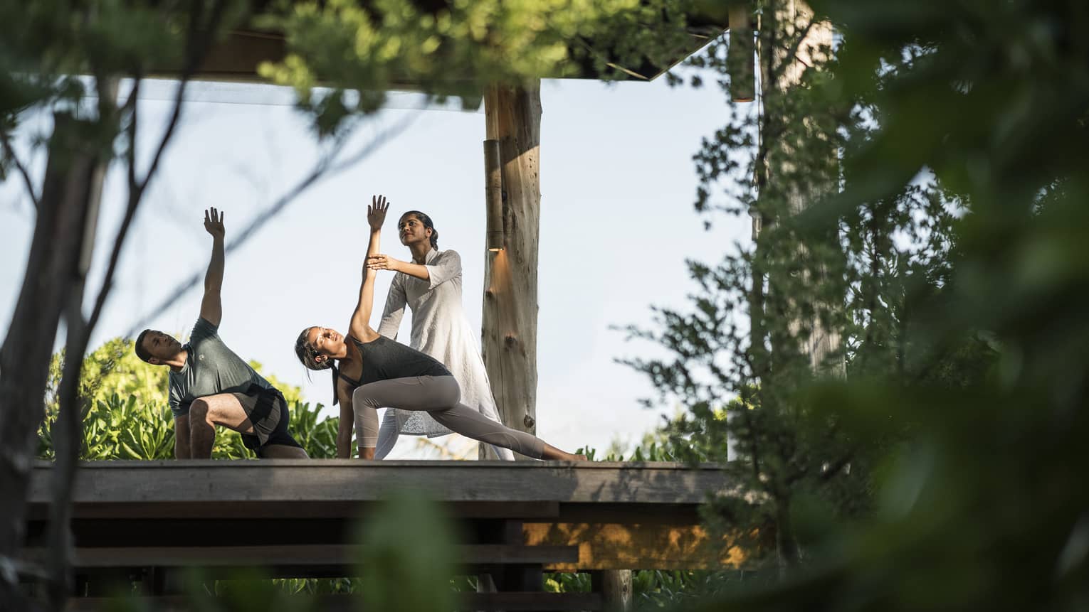 Couple stretching during outdoor yoga class