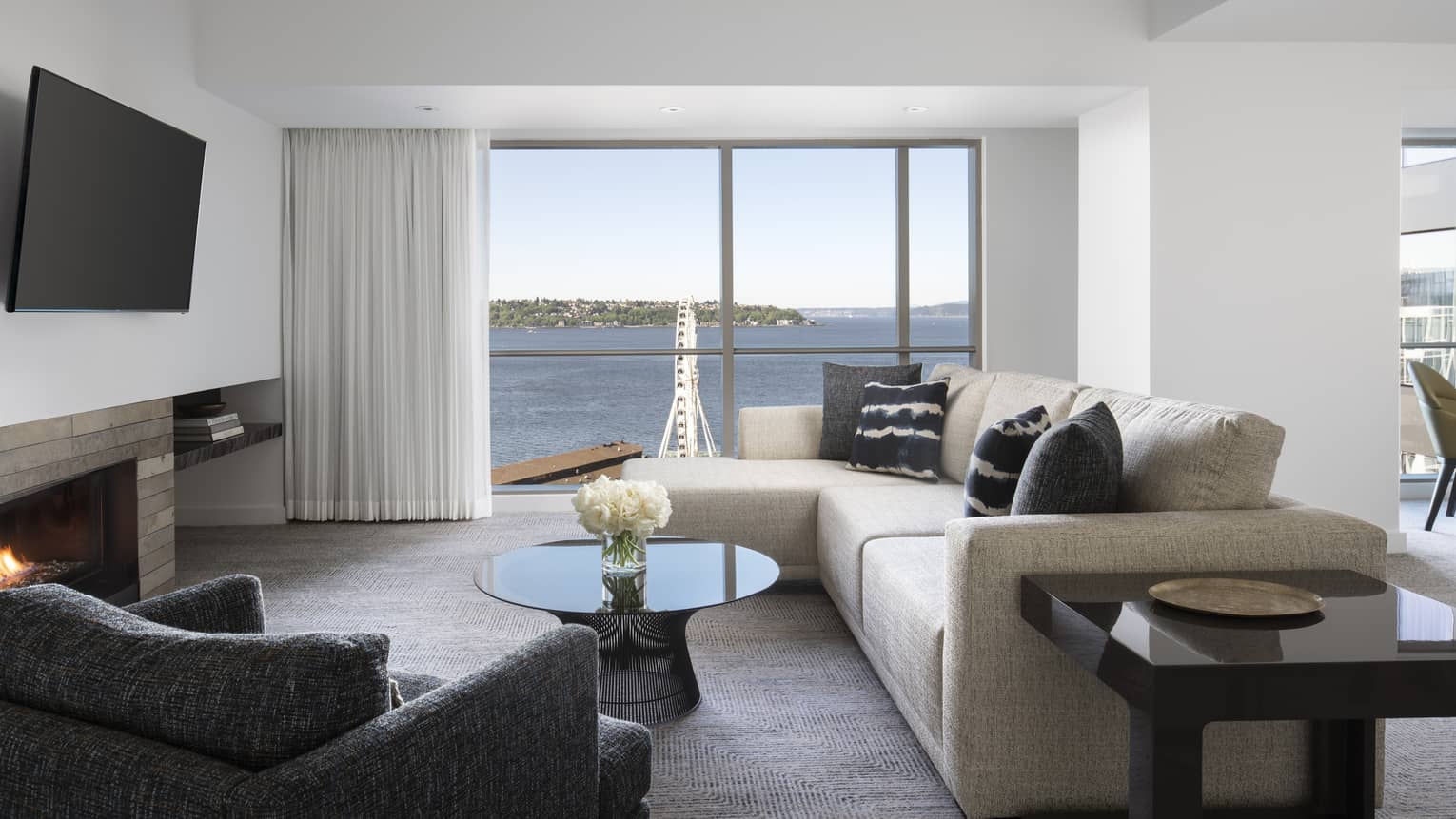The Deluxe Elliot Bay Suite living room has comfortable couches and a view of the Seattle Great Wheel